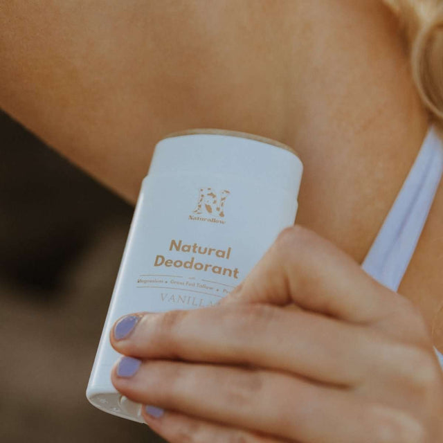 A close-up shot of a woman applying Naturallow's Vanilla Natural Deodorant to her underarm