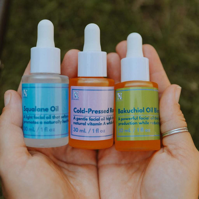 Naturallow's Treatment Oil Trio being held together in a woman's palms