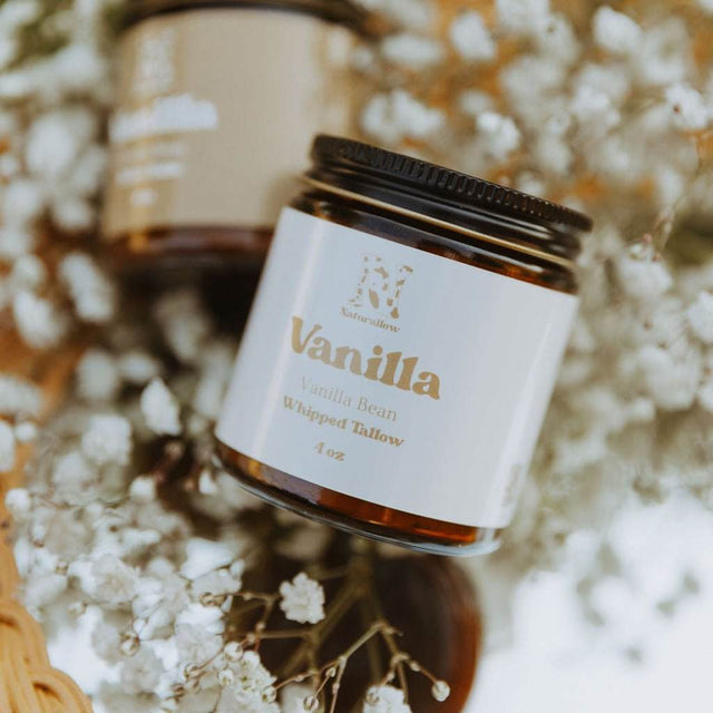 Naturallow's Vanilla Whipped Tallow Moisturizer for dry skin in front of flowers on a woven basket