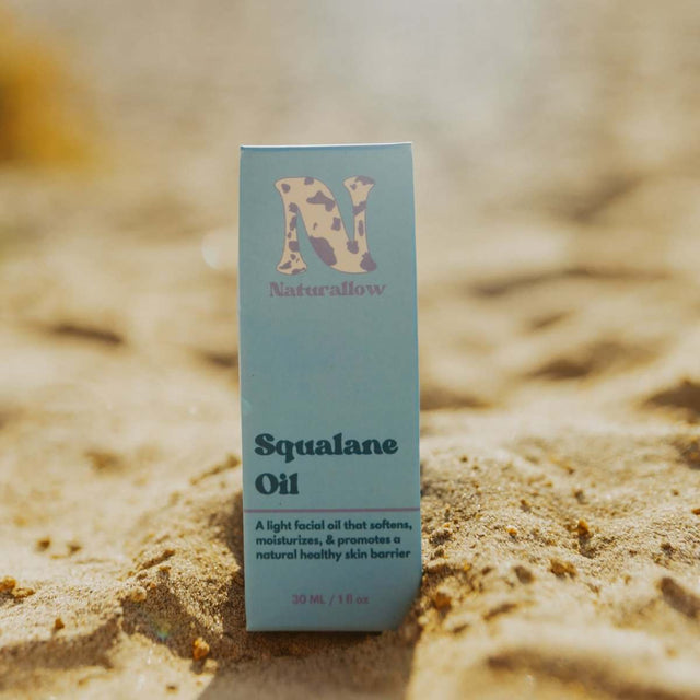 Naturallow's Organic Squalane Oil box sitting in the sand