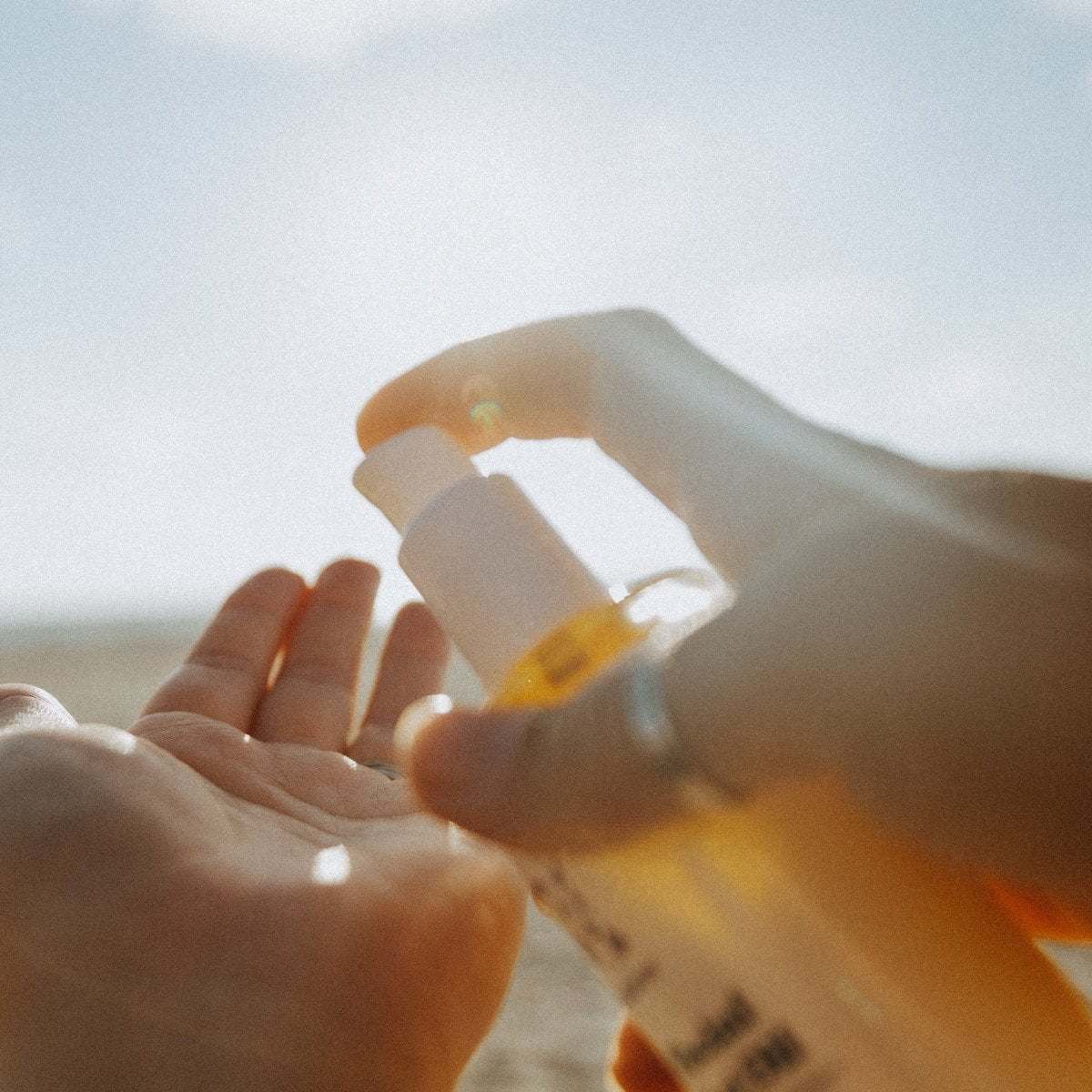 Naturallow's Milky Facial Cleansing Oil being pumped into a hand with the horizon in the background