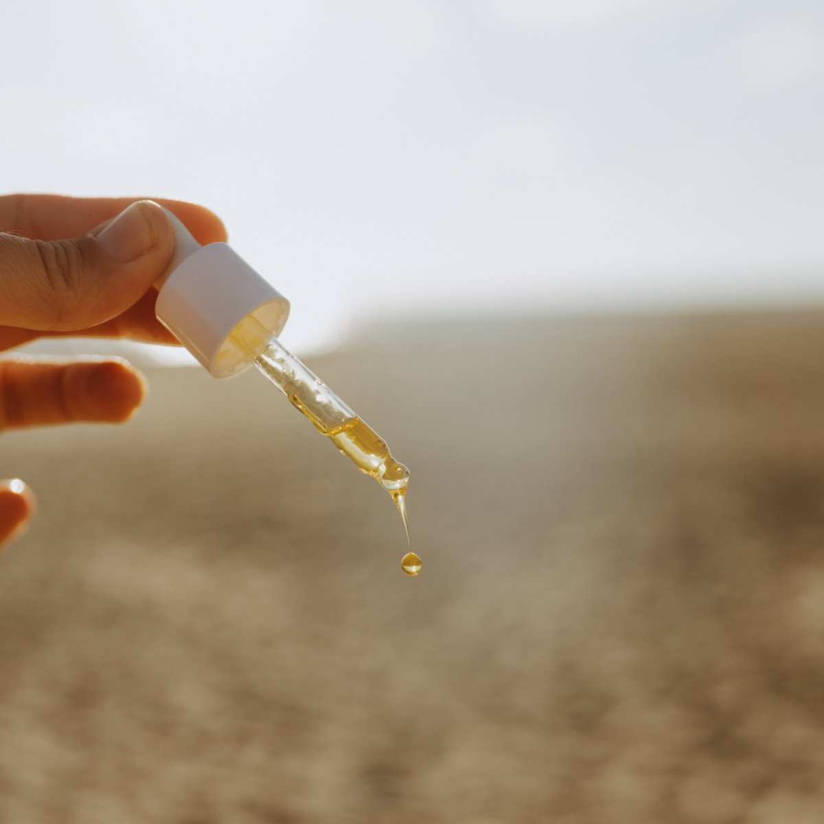 Naturallow's Organic Cold-Pressed Rosehip Oil dripping out of the dropper top