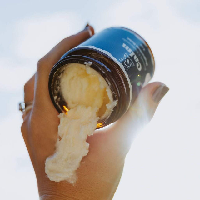 Naturallow's Tallow Magnesium Balm Jar being tipped upside-down in a with the contents pouring out