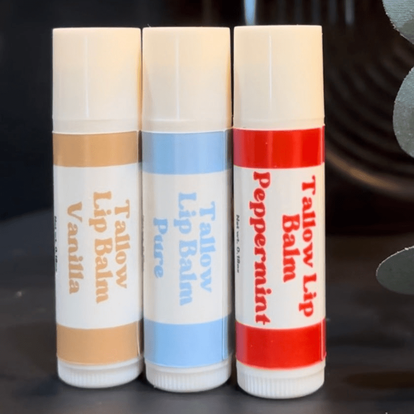 3 of Naturallow's Vanilla, Peppermint, and Pure Unscented Tallow Lip Balms Standing Side-By-Side Touching