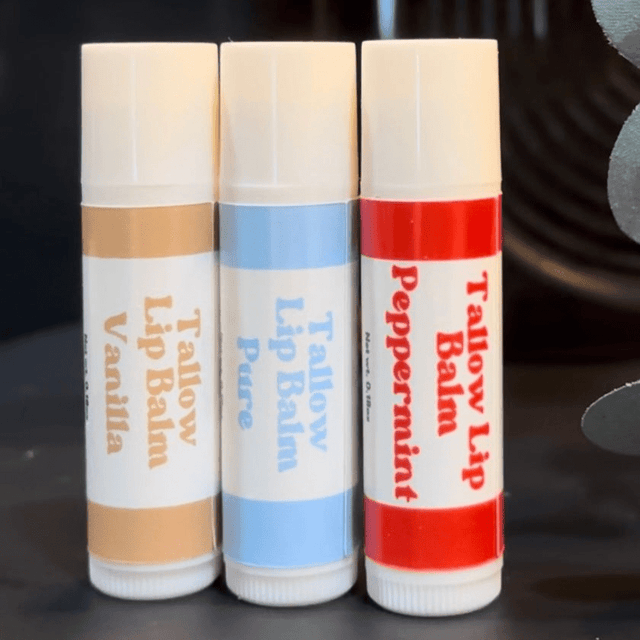 3 of Naturallow's Vanilla, Peppermint, and Pure Unscented Tallow Lip Balms Standing Side-By-Side Touching