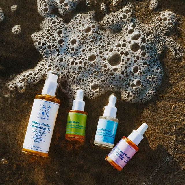 Naturallow's 3-Step Barrier Repair Bundle product image consisting of facial oil bottles laying in the shallow beach tide
